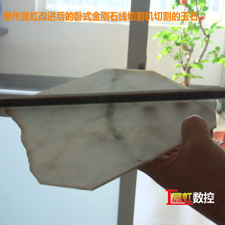 圖為泰州晨虹CHSX5650-XW型數(shù)控金剛石線切割機切割的玉石